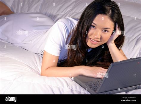 Woman Lying Down On Bed Working On A Laptop Stock Photo Alamy