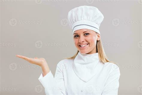 Portrait Of Beautiful Female Chef Gesturing On Gray Background