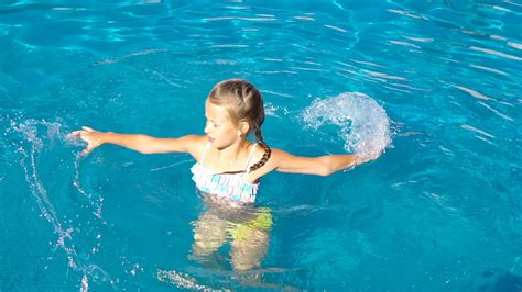 Adorable little girl in outdoor swimming pool 20010343 Stock Video at Vecteezy