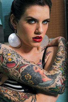 A Woman With Tattoos And Piercings On Her Arm Posing For A Photo In