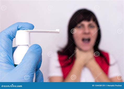 Doctor Holds Spray Medicine For Sore Throat In The Background A Girl