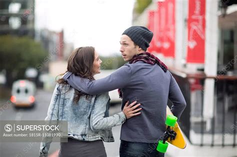 Young Couple Walking Arm In Arm On The Street Superstock