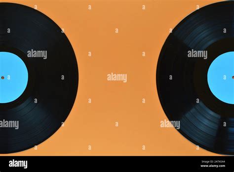 Two Old Black Vinyl Records With Blank Cyan Labels Half On Orange