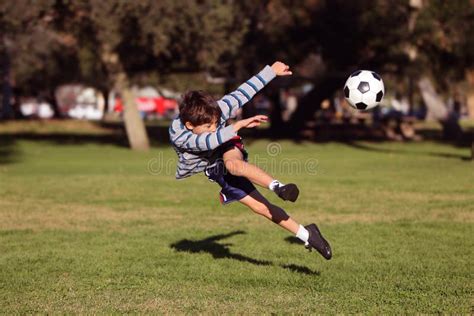 Menino Que Retrocede A Bola De Futebol Foto De Stock Imagem De Jogar