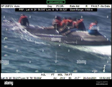 Seven People Sit Upon The Hull Of A Capsized Boat Before Being Rescued