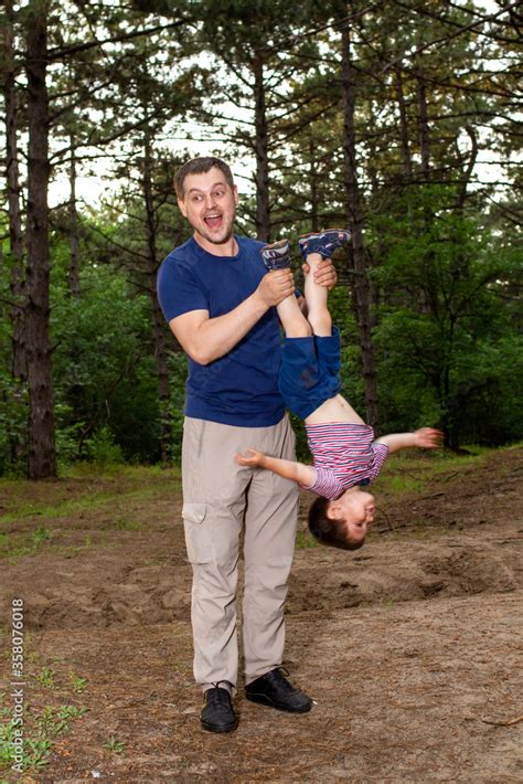 Dad holds his son's legs upside down. Father-son relationships, Father ...