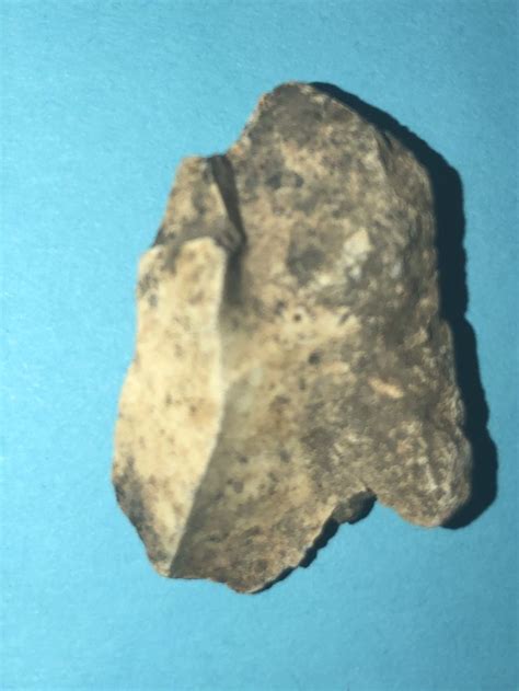 A Piece Of Rock Sitting On Top Of A Blue Surface