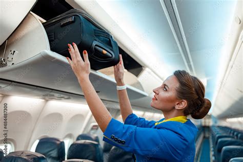 Foto De Woman Flight Attendant Or Air Hostess Placing Travel Bag In