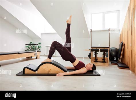 Une Jeune Fille Fait Pilates Sur Un Lit Reformeur Dans Un Studio Lumineux Un Brunette Mince