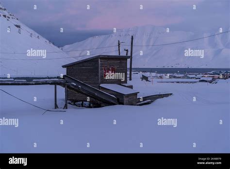 Raised Pipes And Infrastructure Timber Hut In Snowy Landscape On Winter