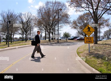 Man Crossing Road Near The Pedestrian Crossing Sign Stock Photo Alamy