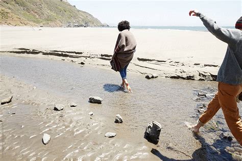 Couple Walking In Sand At The Beach While Traveling On Vacation By