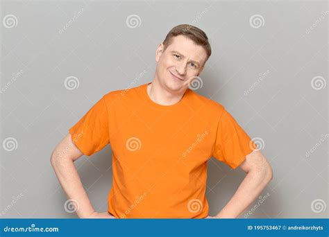 Portrait Of Happy Blond Mature Man Wearing Orange T Shirt Stock Image