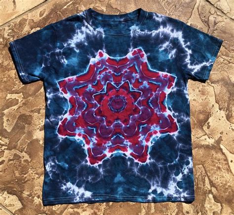 A Red And Blue Tie Dyed T Shirt On A Marble Floor With Water Droplets