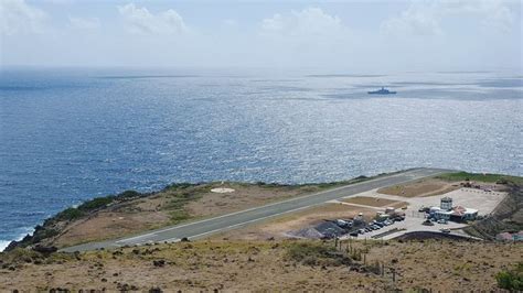 an airplane landing strip in the middle of the ocean with a ship in the ...