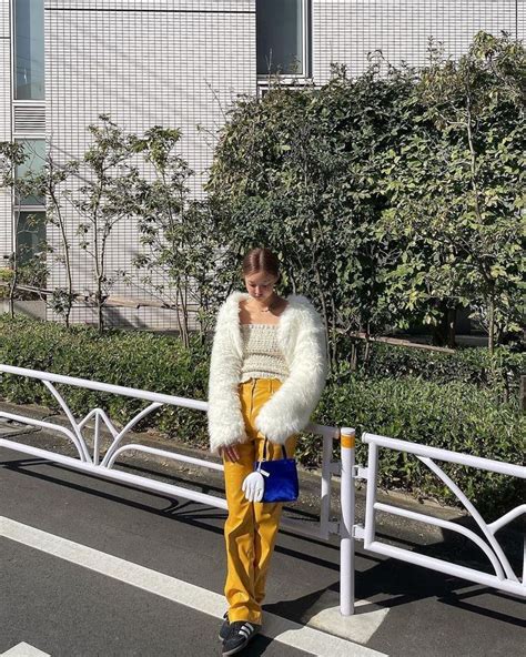 A Woman Wearing Yellow Pants And A White Fur Coat