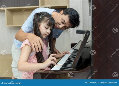 Father And Daughter At Home Playing Music On A Piano Dad And Daughter