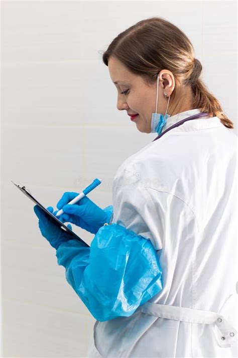 Hermosa Joven Doctora Con Máscara De Traje Médico Y Guantes Azules Con