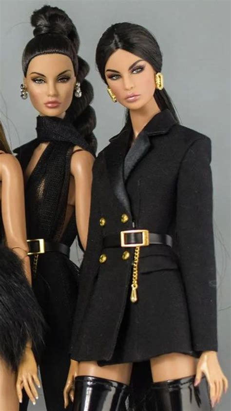 Two Barbie Dolls Are Standing Next To Each Other Wearing Black Clothes