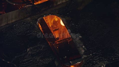 Slow Motion Of Molten Glass Pouring Out Of A Glass Melting Furnace In A Bottle Production