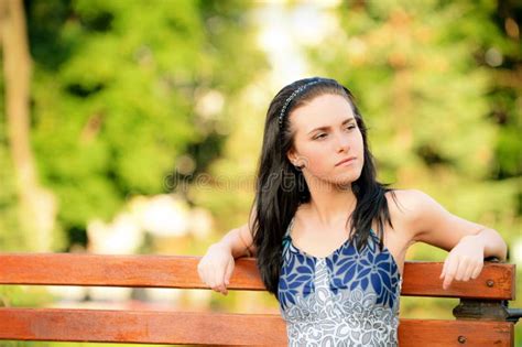 El Brunette Hermoso Se Sienta En Banco Foto De Archivo Imagen De Elegancia Moderno