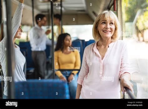 Beautiful Smiling Mature Woman Taking Bus Looking Out Window Stock