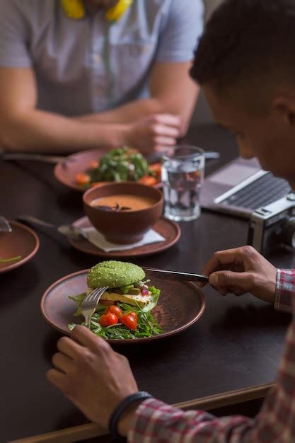 Foto De Pessoas Sentadas Em Um Caf Ou Restaurante Vegano Comendo Um