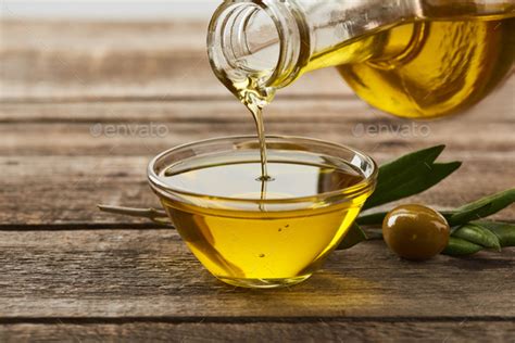 Pouring Oil From Bottle Into Glass Bowl Olive Tree Leaves And Olive On