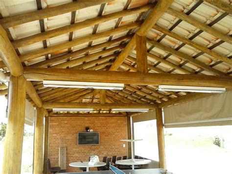 The Inside Of A Building With Wooden Beams And Tables In Front Of It