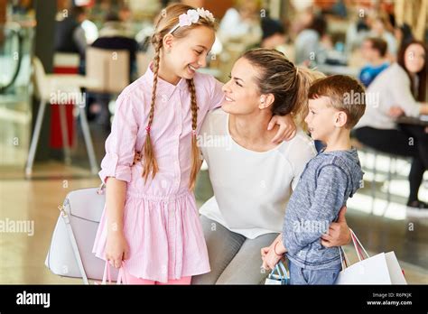 Happy Mother With Two Kids While Shopping In Shopping Mall Stock Photo