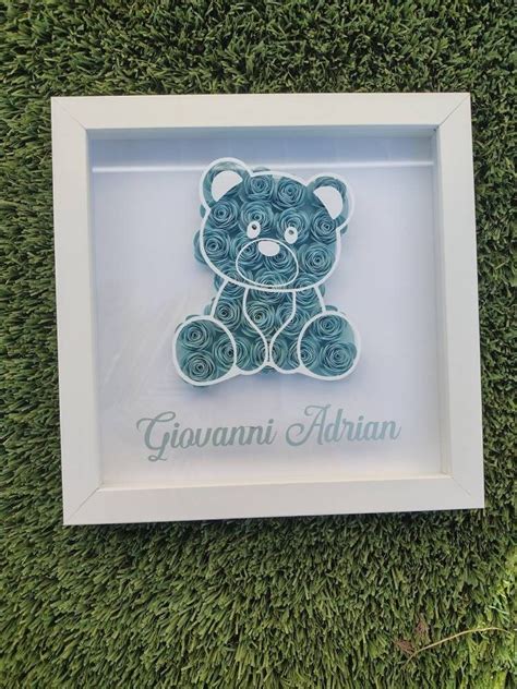 A Blue Teddy Bear In A White Shadow Box With The Words Grandma Written