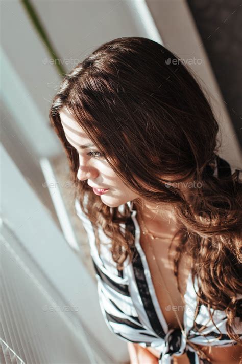 Beautiful Brunette Woman With Natural Hair In Sensual Pose On Bed With Open Shirt And White