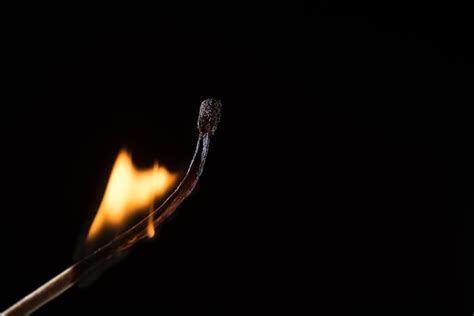 Premium Photo Close Up Of Burning Matchstick Against Black Background