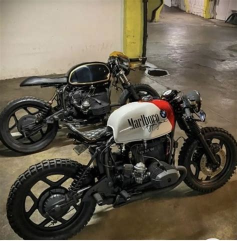 Two Motorcycles Parked Next To Each Other In A Parking Garage With No