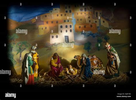 A Nativity Scene Created With Model Figures On Straw Against A Pained