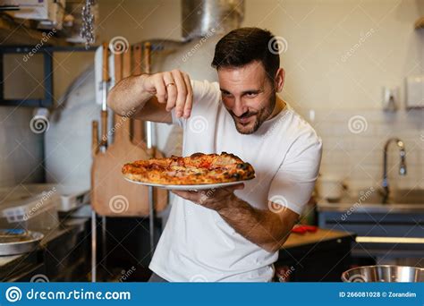 Male Chef Is Sprinkling Fresh Oregano Over A Traditionally Made Home