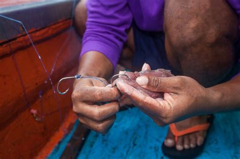 Pescador está haciendo gancho cebo para la pesca en barco de pesca