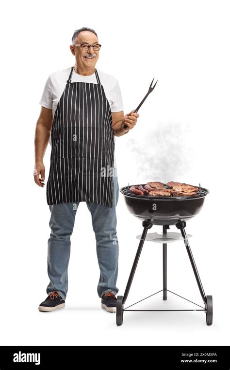 Mature Man Next To A Portable Barbecue Grill Holding A Fork Isolated On