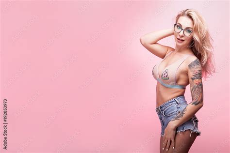 Hot Sexy Busty Blonde Woman Smiling To The Camera On Pink Background