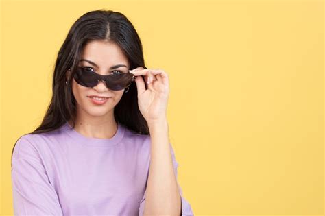 Mujer bajando sus gafas de sol para mirar a la cámara Foto Premium