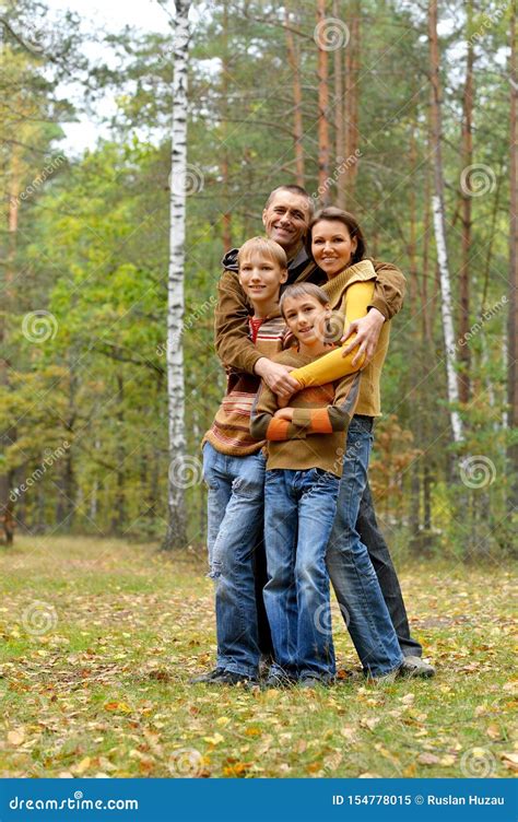 Retrato De La Familia De Cuatro Miembros En Parque Imagen De Archivo