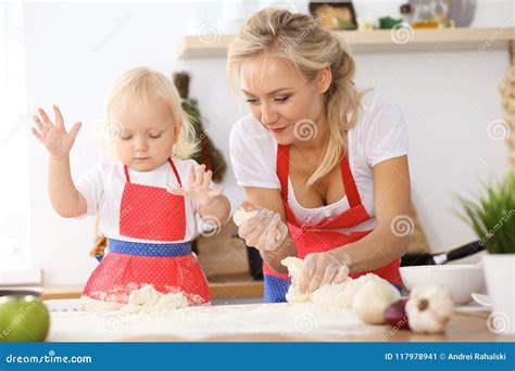 Petite Fille Et Sa Maman Blonde Dans Les Tabliers Rouges Jouant Et