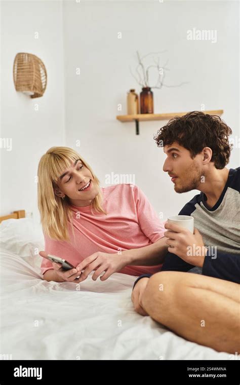 A Loving Gay Couple Shares A Laugh In Their Cozy Inviting Bedroom
