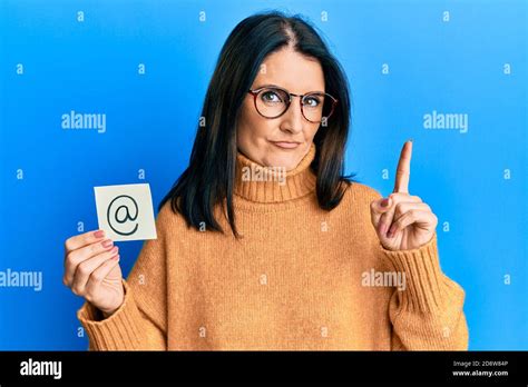 Middle Age Brunette Woman Holding Email Symbol On Paper Smiling With An