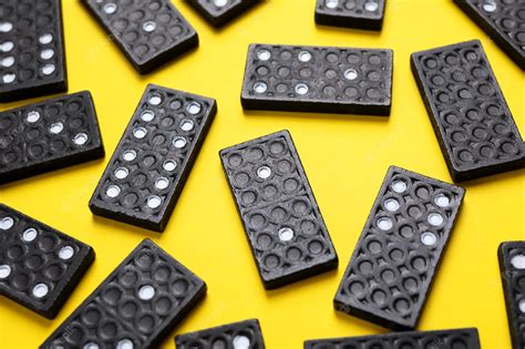 Premium Photo Set Of Black Domino Tiles On Yellow Background