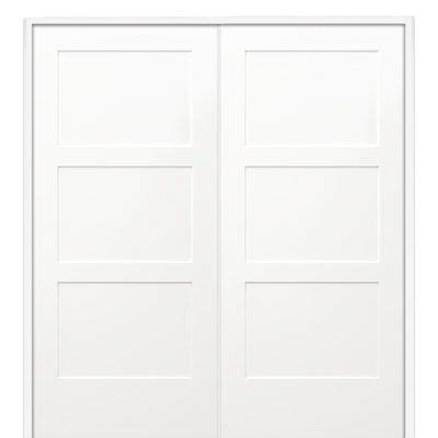 A White Door With Three Panels And Two Panes On The Top Against A