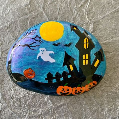 A Painted Rock With Halloween Decorations On It