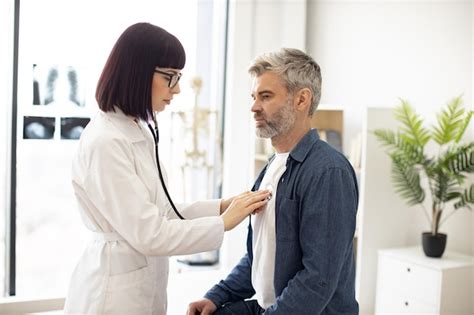 Médico de cabecera usando estetoscopio durante el chequeo del paciente