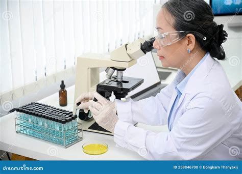 A Professional Asian Aged Female Scientist Examining A Virus Specimen