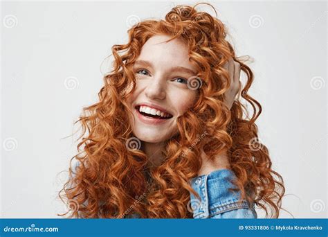 Retrato Da Menina Feliz Bonito Que Sorri Tocando Em Seu Cabelo Vermelho